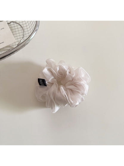 Scrunchie in solid color placed next to matching accessories