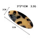 Beau Sweet Oval Acetate Hair Clip holding a section of brown hair