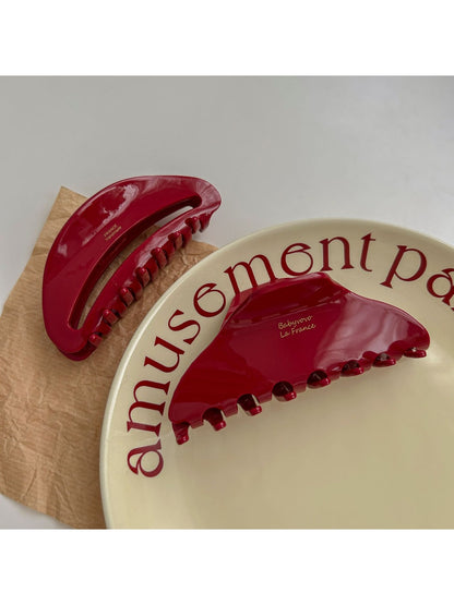 Beau red fashion hair clip shown from side angle highlighting curved design