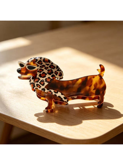 Beau claw clip held in hand showing size and cartoon dachshund design