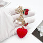 Cherry heart charm keychain attached to a gold keyring with a white backdrop
