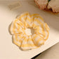 Close-up of yellow striped scrunchie fabric texture and elastic band