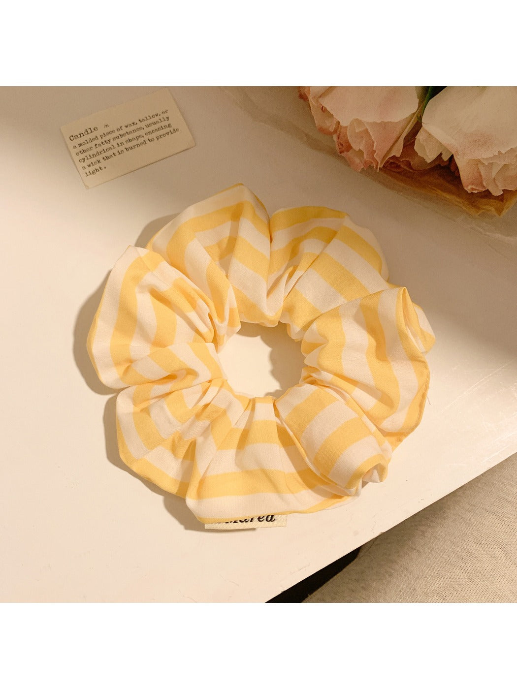 Close-up of yellow striped scrunchie fabric texture and elastic band