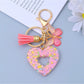 Keypus keychain with heart cutout shown hanging from a hook