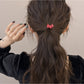Gifty hair tie worn on a wrist displaying the cartoon puppy charm and beads