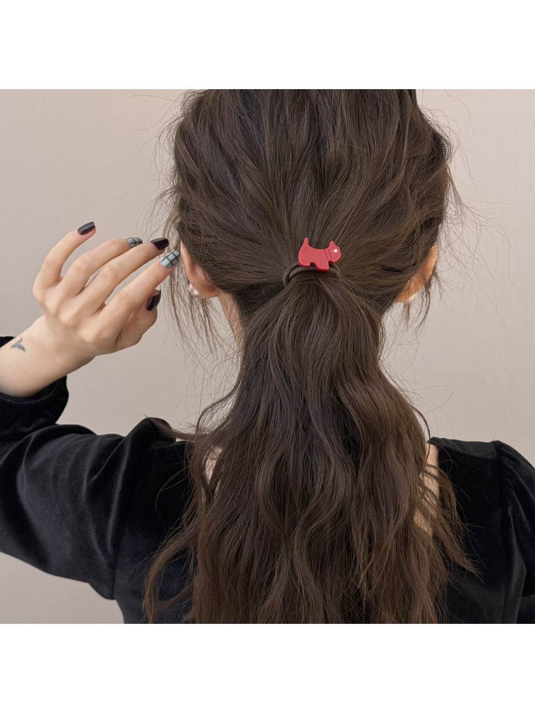 Gifty hair tie worn on a wrist displaying the cartoon puppy charm and beads
