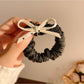 Vintage polka dot bow hair tie in black and white on a plain background