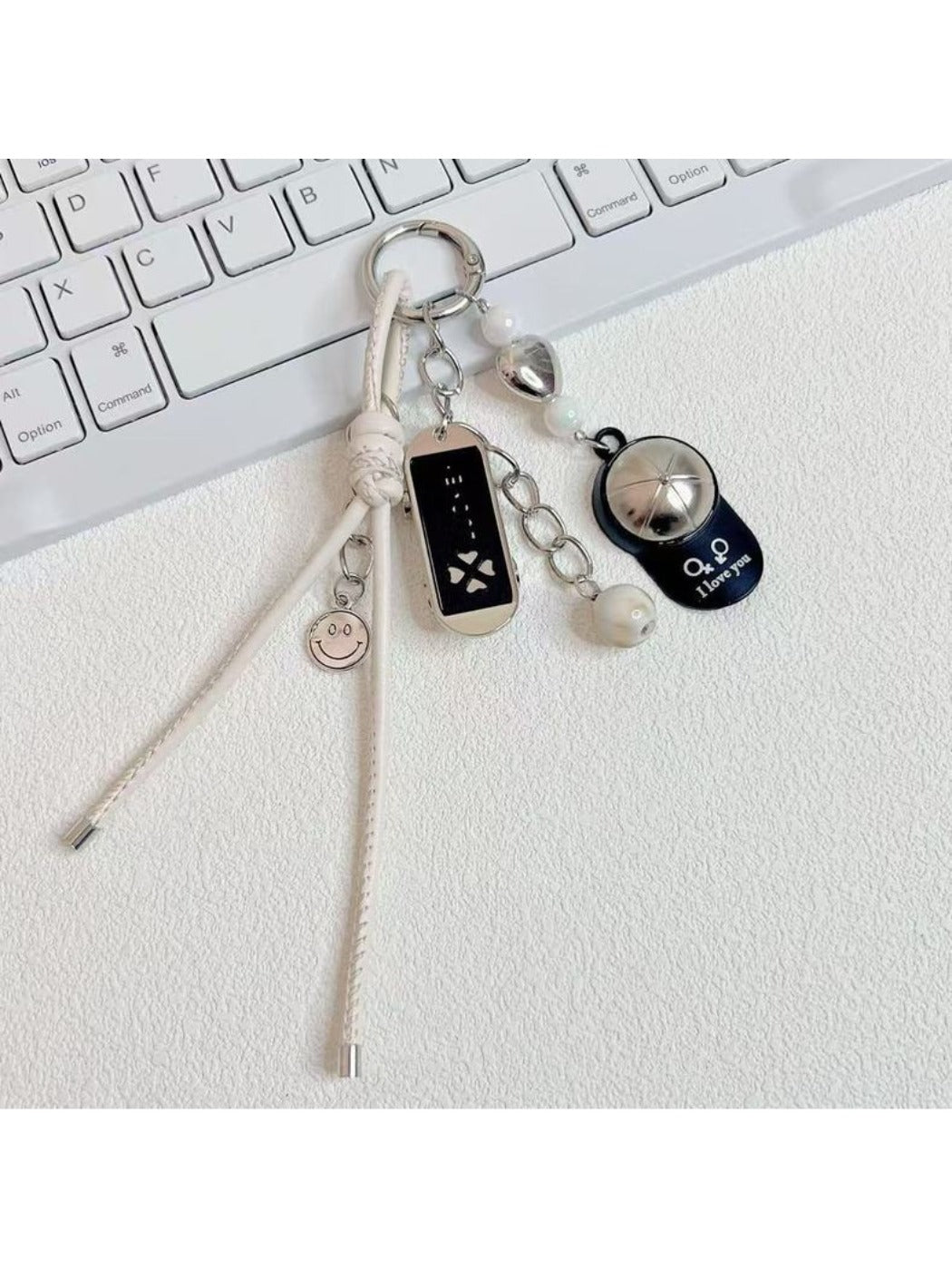 Baseball cap shaped keychain in red with white stitching and silver key ring