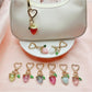 Keypus strawberry charm keychain displayed on a pink fabric background