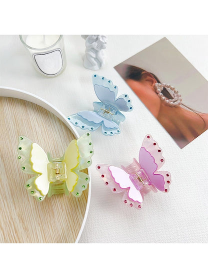 Close-up of pastel pink butterfly claw clip showing detailed wing design