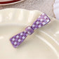 Purple plaid hair claw clip with metal spring detail close-up