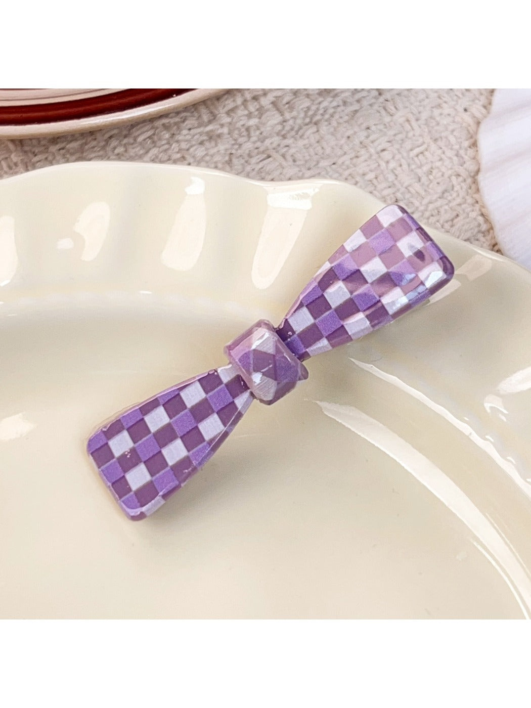 Purple plaid hair claw clip with metal spring detail close-up