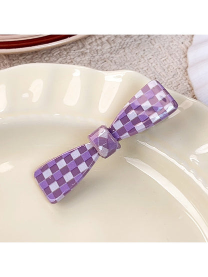 Purple plaid hair claw clip with metal spring detail close-up