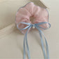 Close-up of Gifty scrunchie showing ruffled texture and bow detail