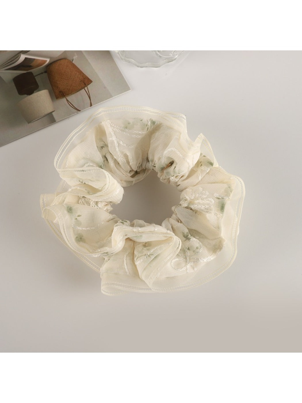 Gifty floral scrunchie laid flat, emphasizing its layered tulle and fabric flowers