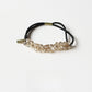 Gifty hair tie placed next to matching accessories on a wooden surface