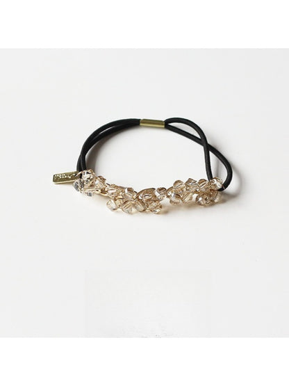 Gifty hair tie placed next to matching accessories on a wooden surface
