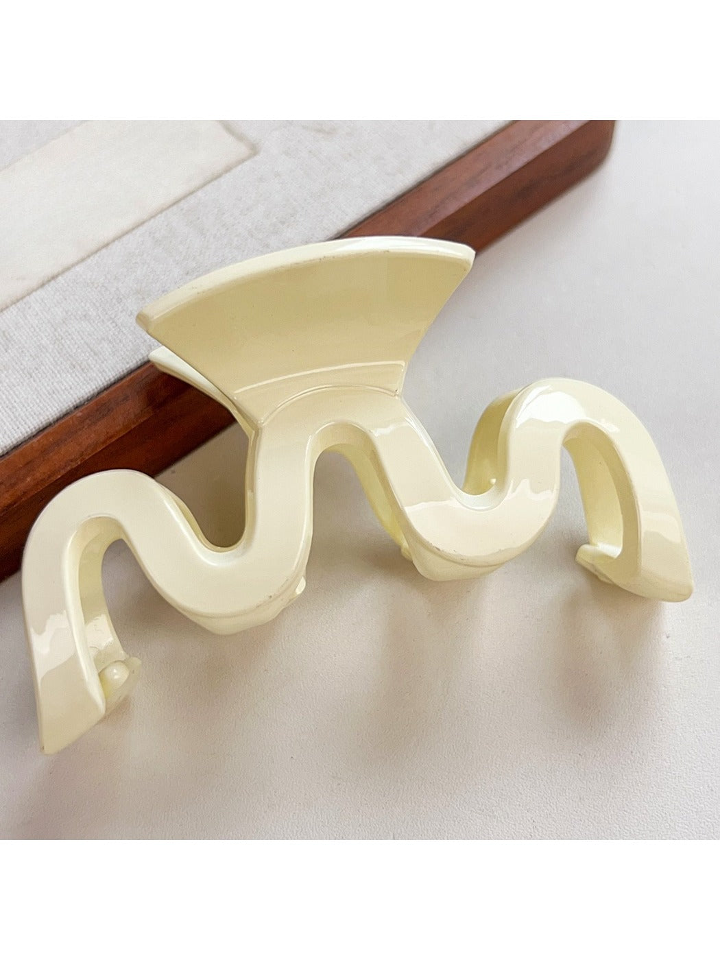 Beau minimalist hair claw clip in light pink color displayed on fabric
