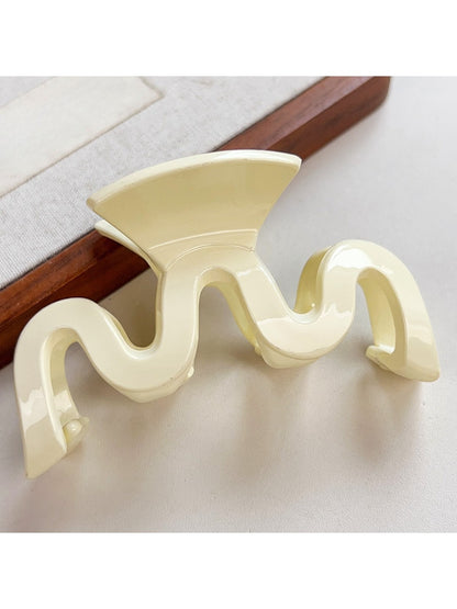 Beau minimalist hair claw clip in light pink color displayed on fabric