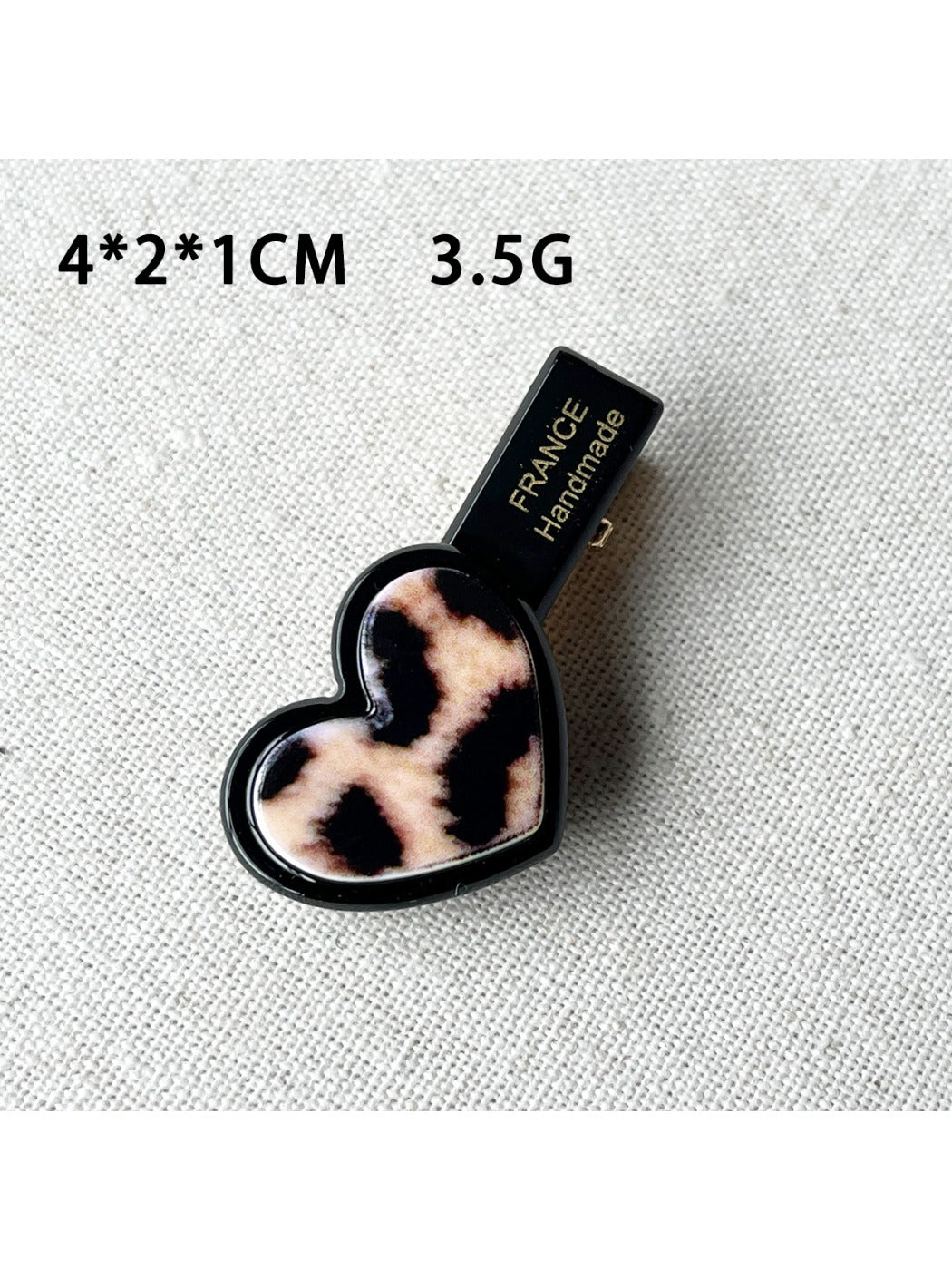Top view of Beau acrylic hair clip highlighting pink flower and heart design