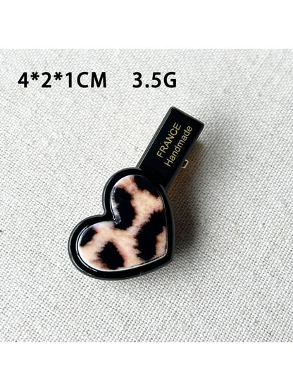 Top view of Beau acrylic hair clip highlighting pink flower and heart design