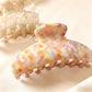 Side angle of Beau chic tiny floral acetate claw clip highlighting clip teeth