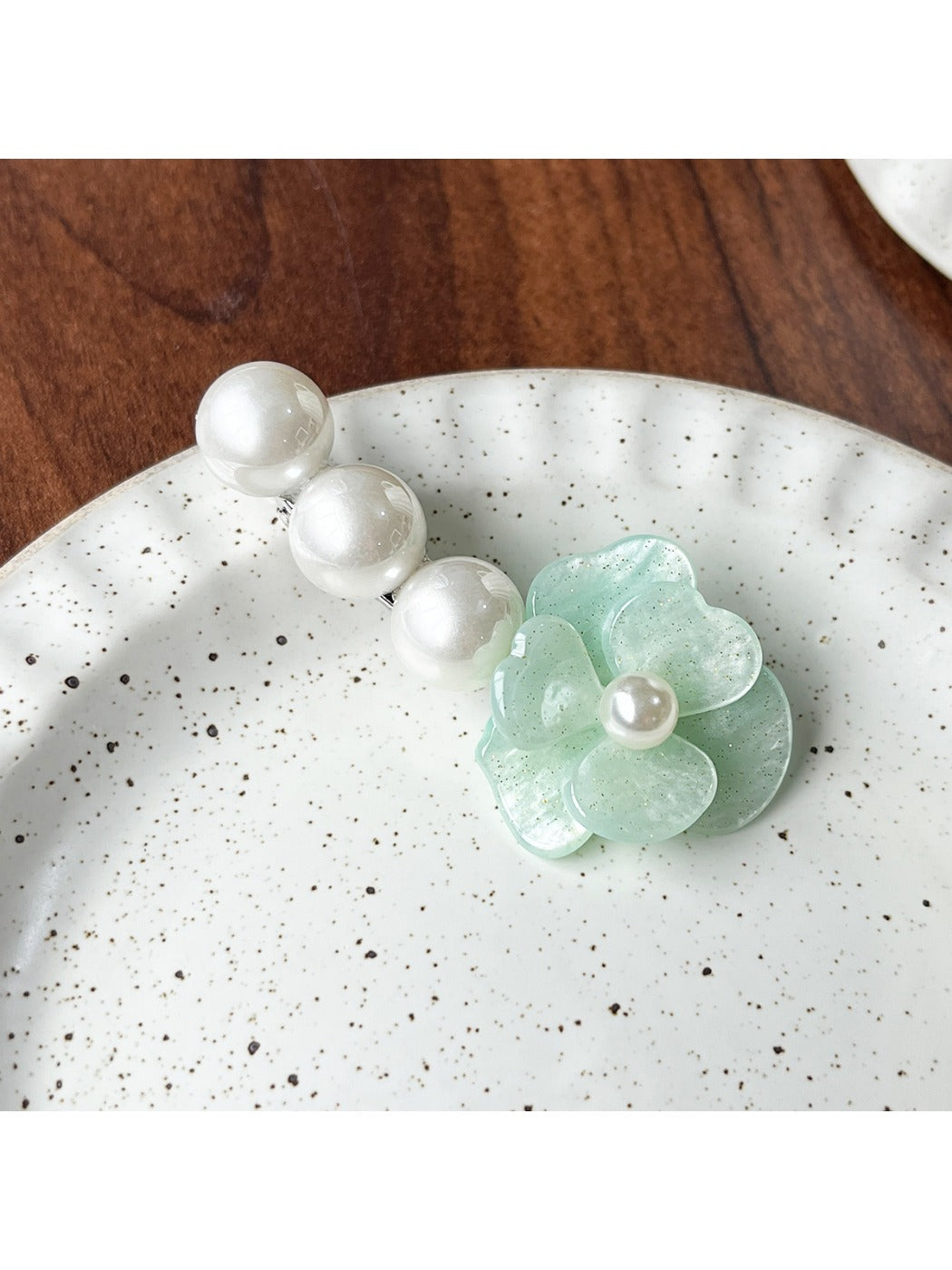 Beau Camellia hair clip placed on a fabric surface highlighting texture