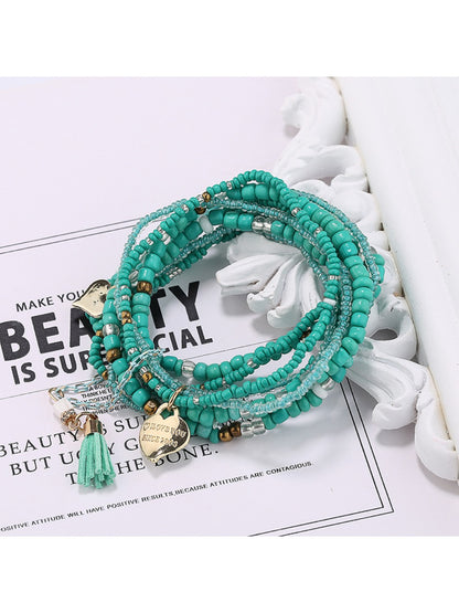 Lovra bracelet with heart pendant placed on textured surface for product display