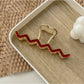Beau wavy metal claw clip positioned upright on white surface
