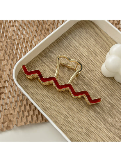 Beau wavy metal claw clip positioned upright on white surface