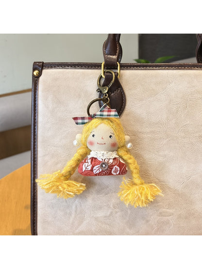Vintage girl charm keychain photographed against a plain background for clear view