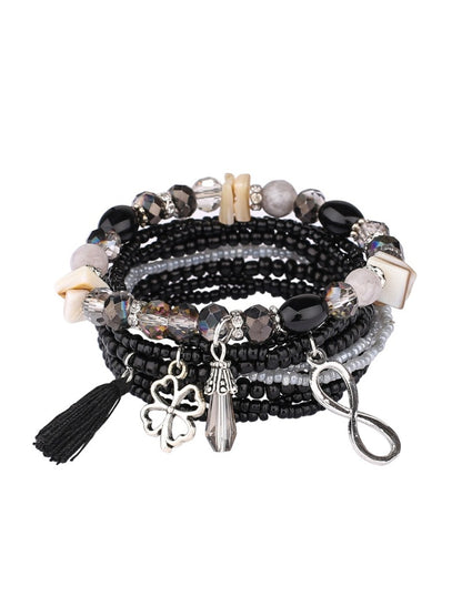 Detailed shot of tassel charm on Lovra vintage stackable beaded bracelet