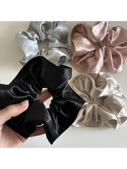 Gifty satin scrunchie displayed flat with gentle folds highlighting satin sheen