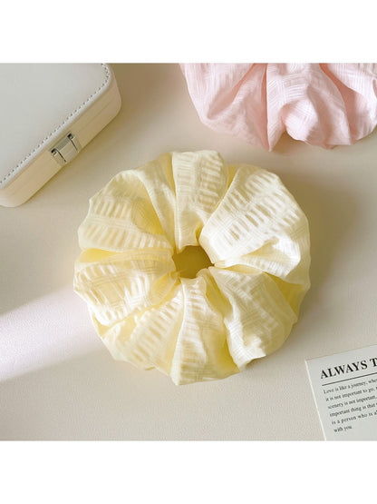 Close-up of Gifty scrunchie showing detailed checkered fabric texture and stitching