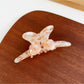 Beau bow adorned hair claw clip photographed on marble surface