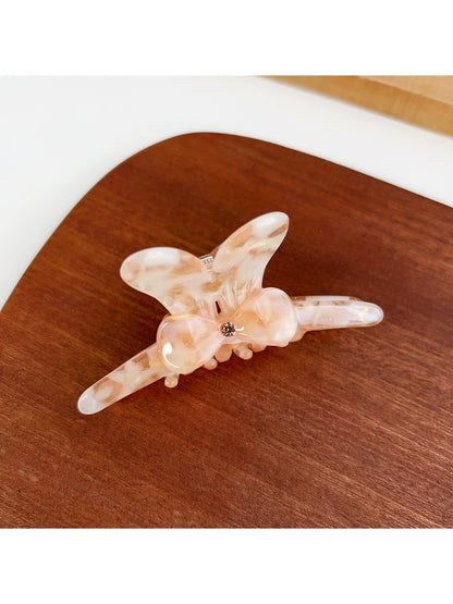 Beau bow adorned hair claw clip photographed on marble surface