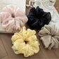 Side view of the ruched scrunchie highlighting its smooth fabric finish