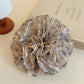 Close-up of Gifty vintage print scrunchie showing ruched texture and floral design