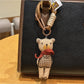 Side view of fabric bear cub bag charm with visible fabric texture