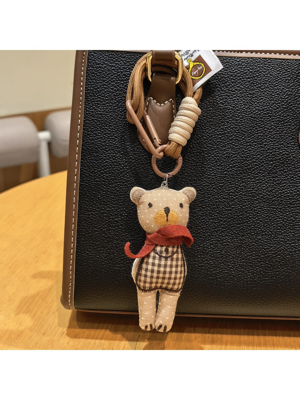 Side view of fabric bear cub bag charm with visible fabric texture