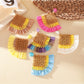 Close-up of vintage square raffia drop earrings with woven texture on white background