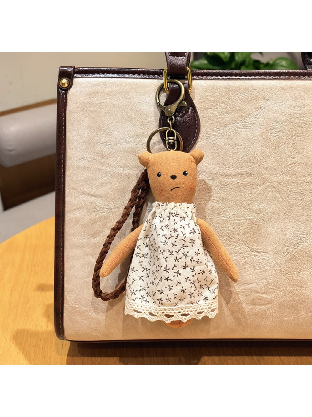 Cartoon bear charm keychain held in hand to show size and scale