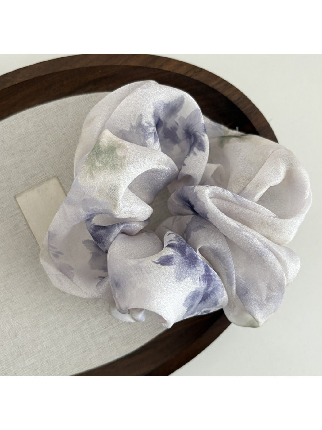 Detailed shot of Gifty satin scrunchie fabric with colorful floral design