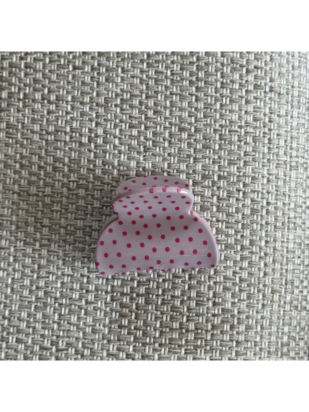 Beau pink polka dot claw clip displayed on a model’s hair from the back