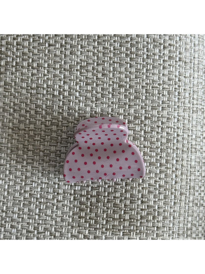 Beau pink polka dot claw clip displayed on a model’s hair from the back