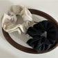 Close-up of Gifty chiffon scrunchie showing layered bow detail in pastel pink