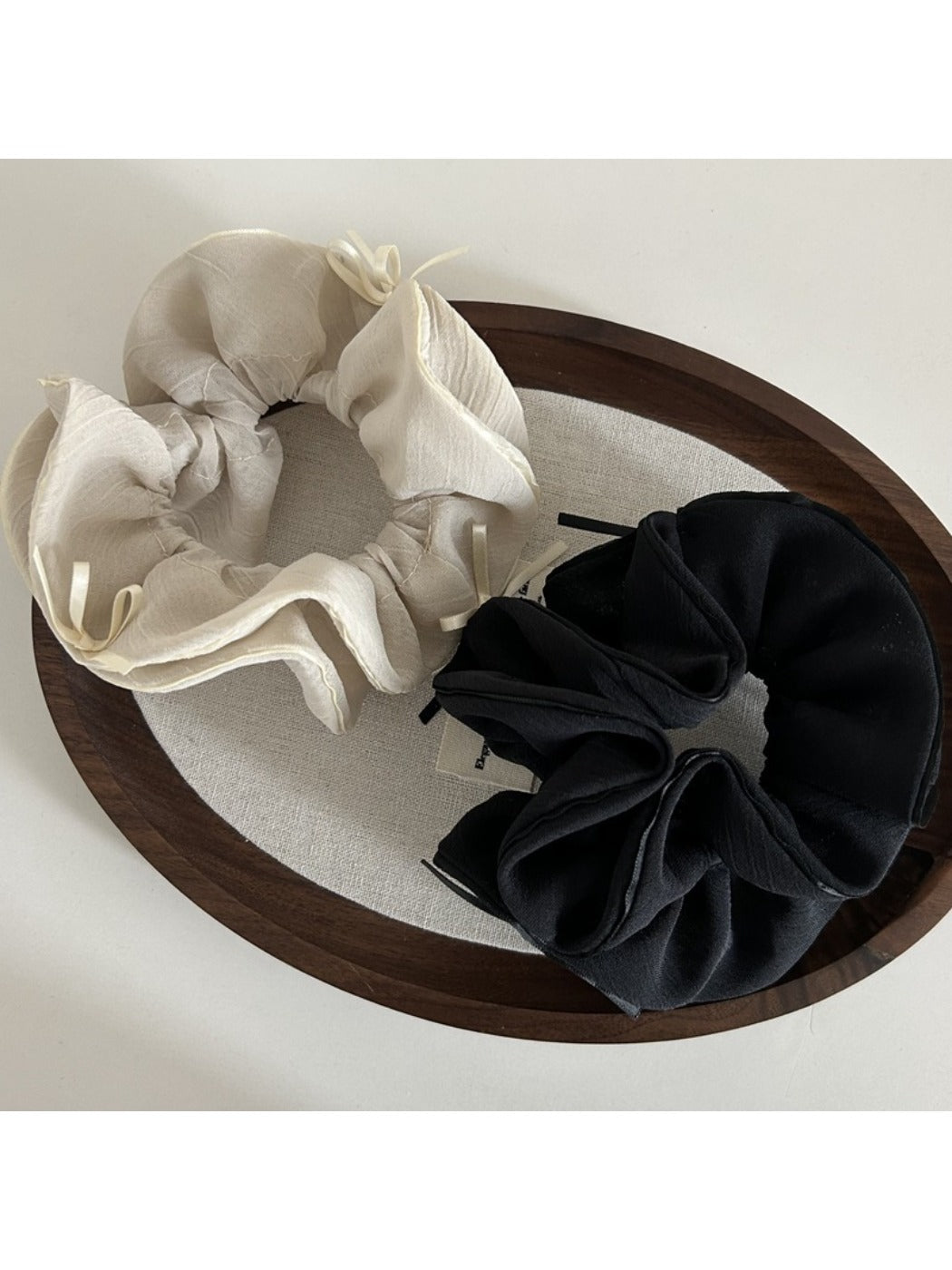 Close-up of Gifty chiffon scrunchie showing layered bow detail in pastel pink