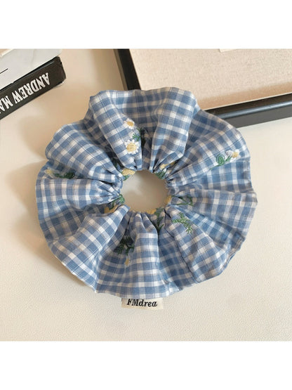 Blue plaid scrunchie stretched to show elastic band inside