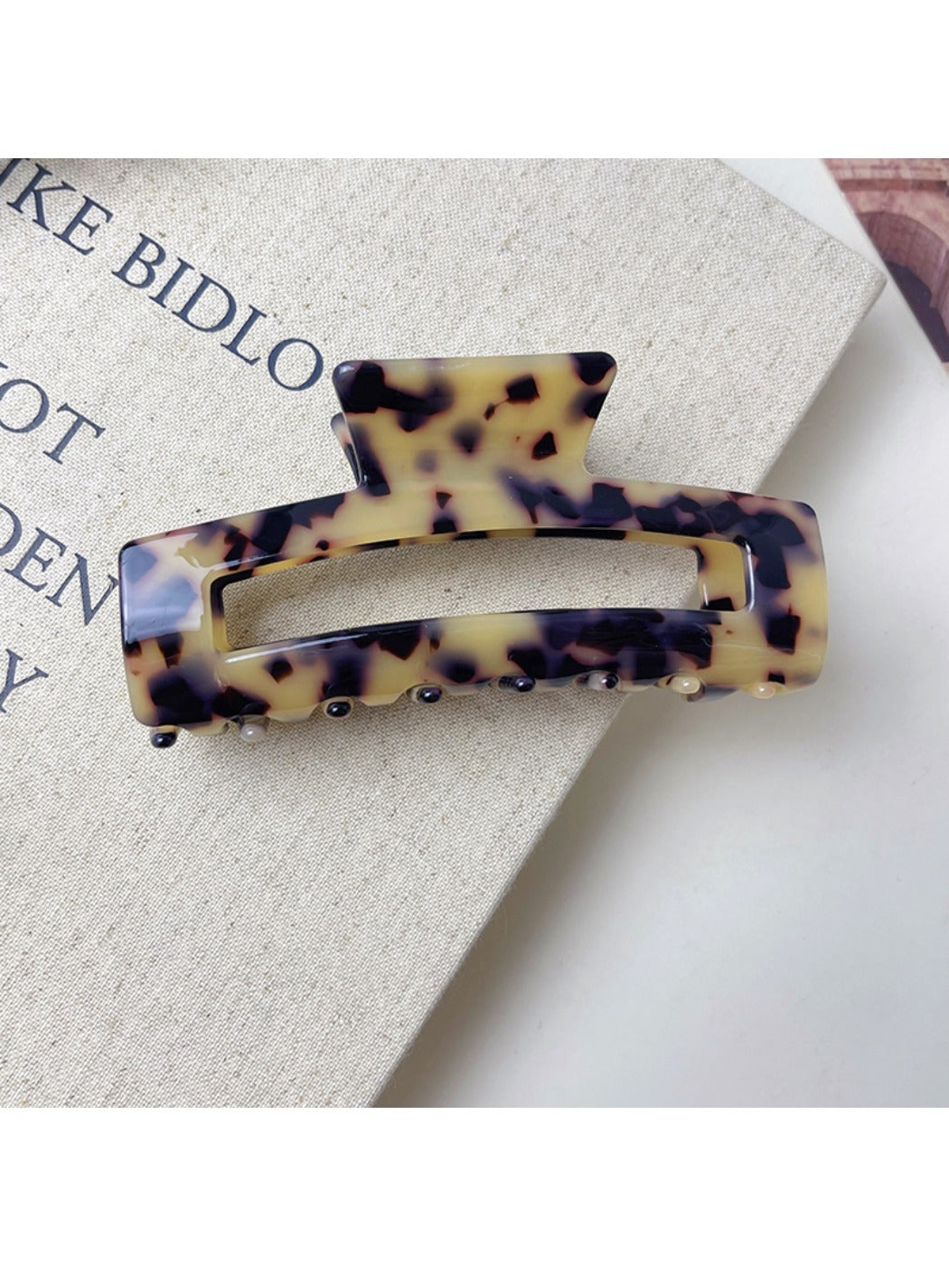 Beau minimalist claw clip displayed on a wooden surface with natural light