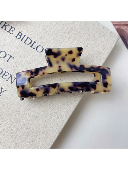 Beau minimalist claw clip displayed on a wooden surface with natural light